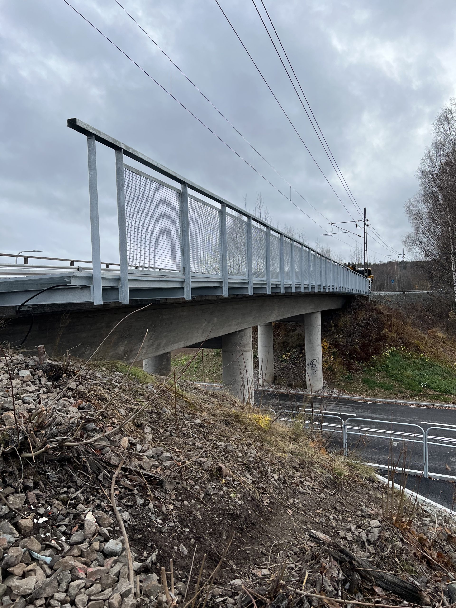 Gångbrygga i varmförzinkat stål med nätramar toppledare och gallerdurk.