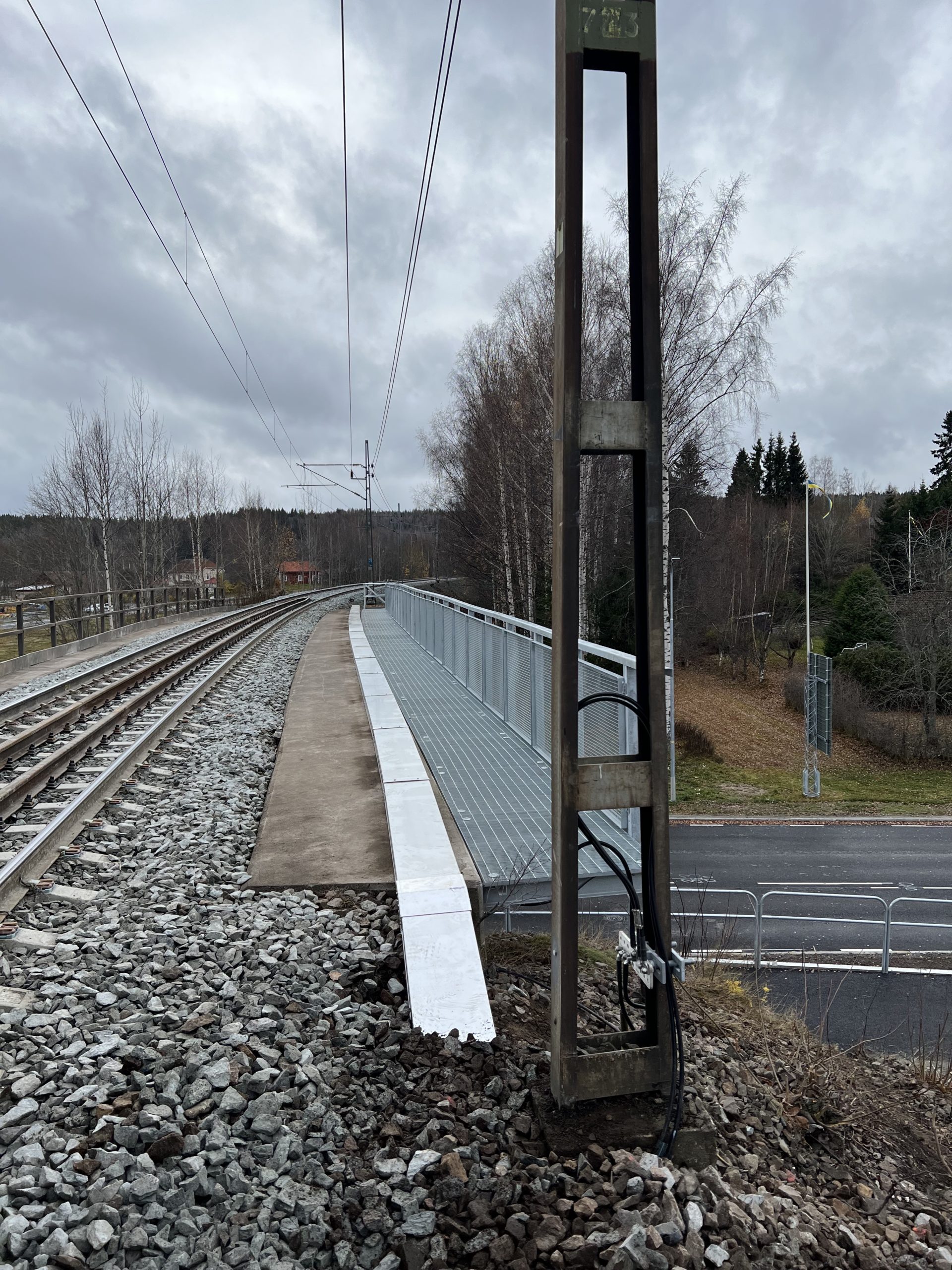 Gångbrygga i varmförzinkat stål med nätramar toppledare och gallerdurk.